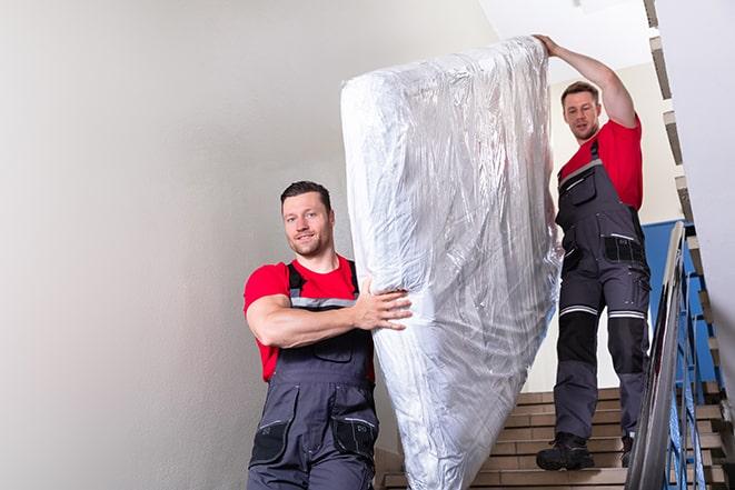 furniture removal experts handling a box spring with care in Canoga Park